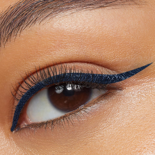 Crzy BFF Liquid Liner by ColourPop outlines the upper lash line in a precise deep navy cat-eye wing, accenting natural lashes on a close-up eyelid; bold matte finish showcases the pigment and control of the ColourPop BFF Liquid Liner.