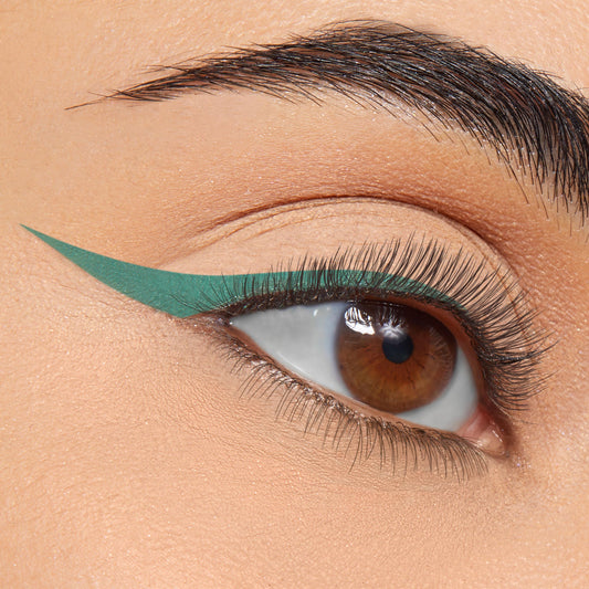 Close-up eye lined with a bold matte teal wing created with ColourPop BFF Liquid Liner in The Hills, showing a clean, precise cat-eye on smooth skin.