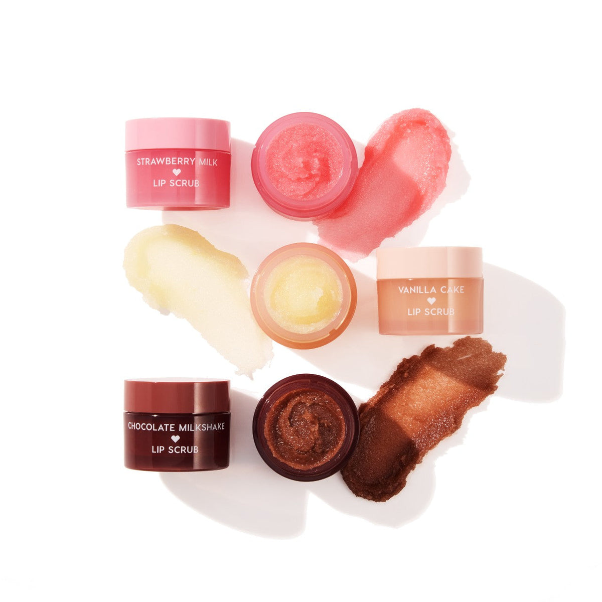 Neapolitan Sundae ColourPop Lip Scrub trio - Strawberry Milk, Vanilla Cake, and Chocolate Milkshake - displayed open with pink, vanilla, and cocoa scrubs swatched beside round jars, showcasing exfoliating texture on a bright white background.