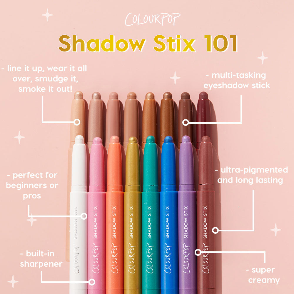 Juicy Gossip Shadow Stix stands upright among a rainbow lineup of ColourPop Shadow Stix, caps off to show creamy tips on a pink backdrop; ultraβpigmented, longβwear, multiβtasking eyeshadow stick with a builtβin sharpener.