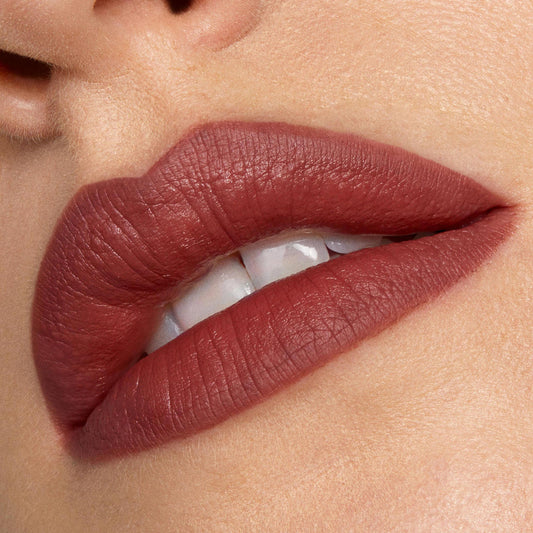 Full lips lined and filled with Grunge ColourPop Lippie Pencil, showcasing a soft-matte warm brown‑rose hue in a tight close-up with teeth slightly visible, emphasizing crisp edges and smooth, even coverage.
