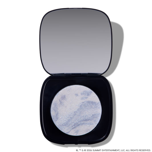 Open compact of Change Me Mega Highlighter with shimmering icy lavender and silver marbled pan set in a sleek black case with mirror, styled on a white background for the Twilight makeup collection.