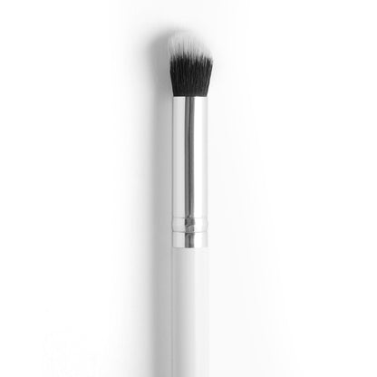 Small Detail Brush blending precise eyeshadow and concealer; dense rounded black-to-white bristles with a polished silver ferrule and white handle, ColourPop makeup brush isolated on a white background.