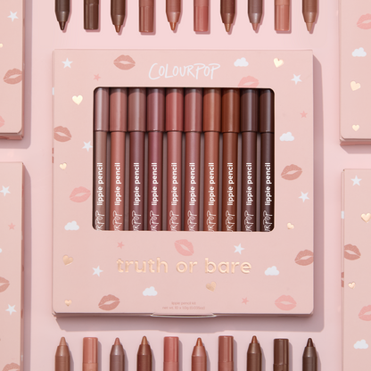 Truth or Bare Lippie Pencil kit by ColourPop displayed in a pink windowed box, 10 nude lip liner shades from peach to deep brown standing upright, surrounded by matching pencils and boxes on a pastel pink background with kiss and star icons.