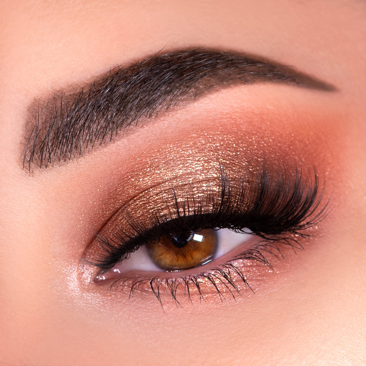 Shimmering copper-bronze eye shadow blends across a closed lid with fluttery lashes, showcasing warm nude tones created with the Nude Mood ColourPop Shadow Palette, featuring a soft matte crease and glowing inner corner highlight.