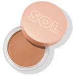ColourPop SOL Face & Body Bronzing Balm in Medium sits open, revealing a smooth warm tan cream in a round clear jar, with a peach lid embossed “SOL BODY,” angled on a white background.
