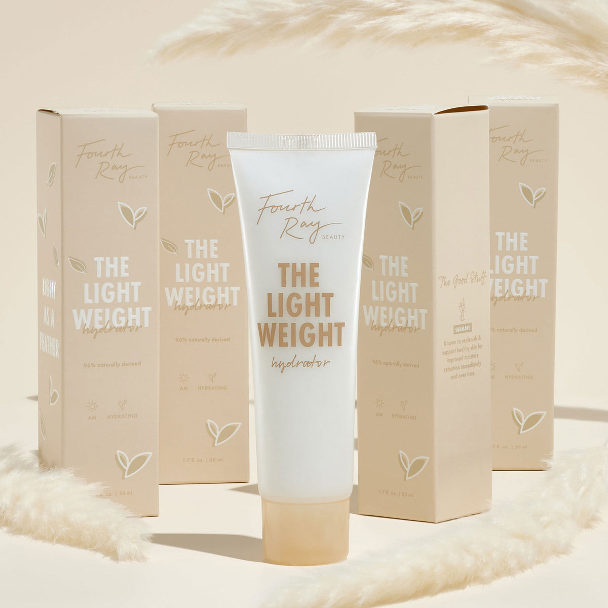 Fourth Ray Beauty The Lightweight hydrator tube standing upright, a ColourPop Face Moisturizer, gold lettering, 1.7 fl oz, surrounded by matching beige cartons and soft pampas accents on a warm cream backdrop.
