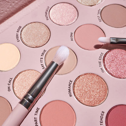 Total Smokeshow ColourPop Shadow Palette & Brush Set featuring two fluffy brushes sweeping over matte nude “Say It’s True” and shimmery rose-gold “Romance” pans, with shades like Every Rose, Alone, and On the Edge in a blush pink tray.