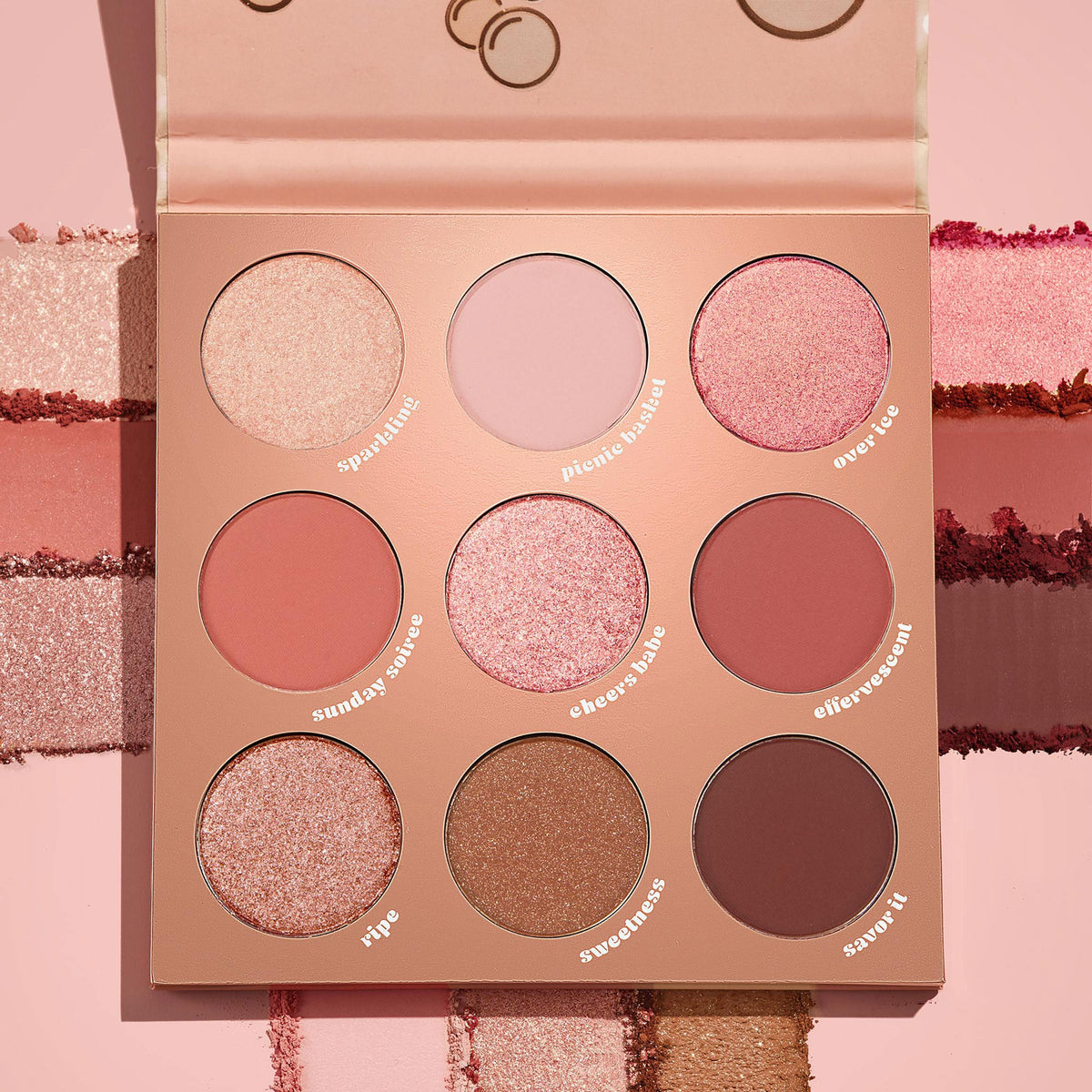 By The Rosé ColourPop Shadow Palette opens to display nine pans of rosé-toned pinks and mauves in matte and shimmer finishes, with shade names like Sparkling, Picnic Basket, and Over Ice, set on a blush background beside swipe swatches.
