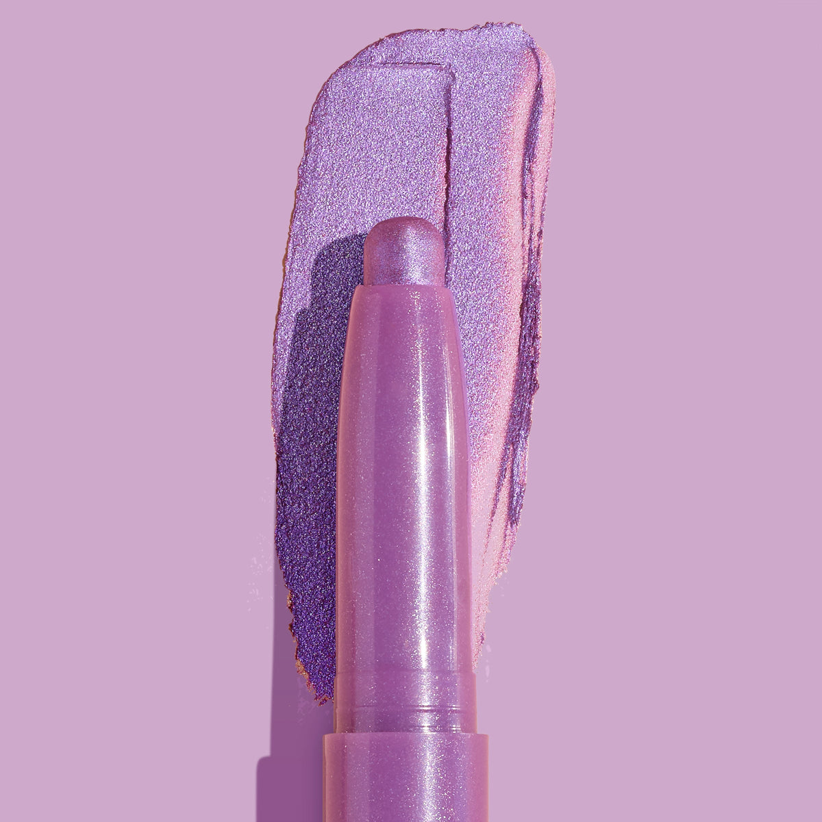 Hey Bestie Shadow Stix lays down a metallic lavender-lilac swatch on a matching purple backdrop, close-up of the creamy twist-up eyeshadow crayon from ColourPop Shadow Stix highlighting its shimmer and smooth texture.
