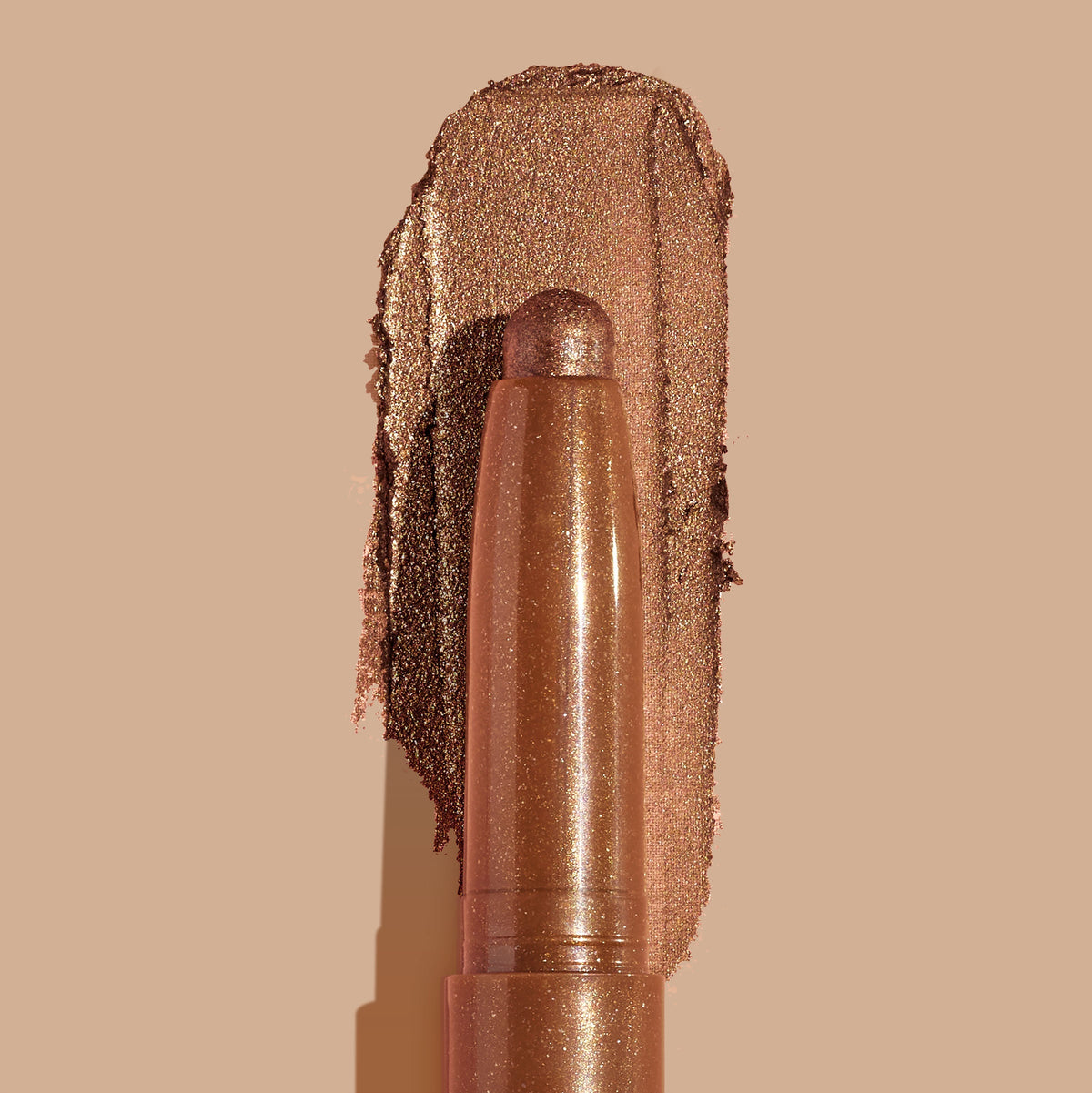 Quokka ColourPop Shadow Stix glides a warm copper-bronze metallic swatch, the creamy eyeshadow stick with a rounded tip centered over its shimmery smear on a nude background.