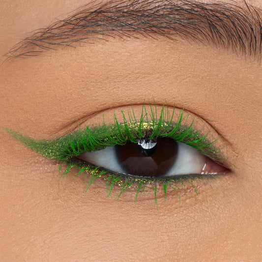Lashes coated in vivid electric-green Roar! ColourPop BFF Mascara, fanning across a brown eye with metallic green winged eyeliner; close-up macro emphasizes saturated pigment and defined upper and lower lashes.