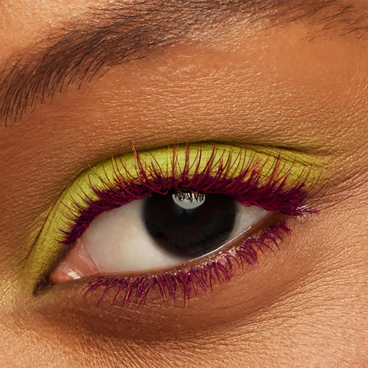 Burgundy-coated lashes wearing ColourPop BFF Mascara in Wine O’Clock, fanning over a deep brown eye and paired with vivid chartreuse eyeshadow in a tight close-up, highlighting bold color payoff and definition.