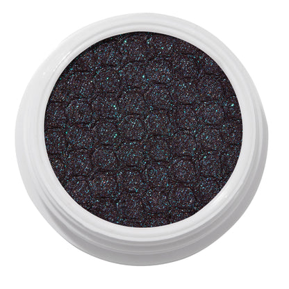 ColourPop Bae Super Shock Shadow shimmering in a white round pot, a deep plum-black cream eyeshadow packed with teal and blue microglitter and a quilted texture, shown close-up on a clean white background.