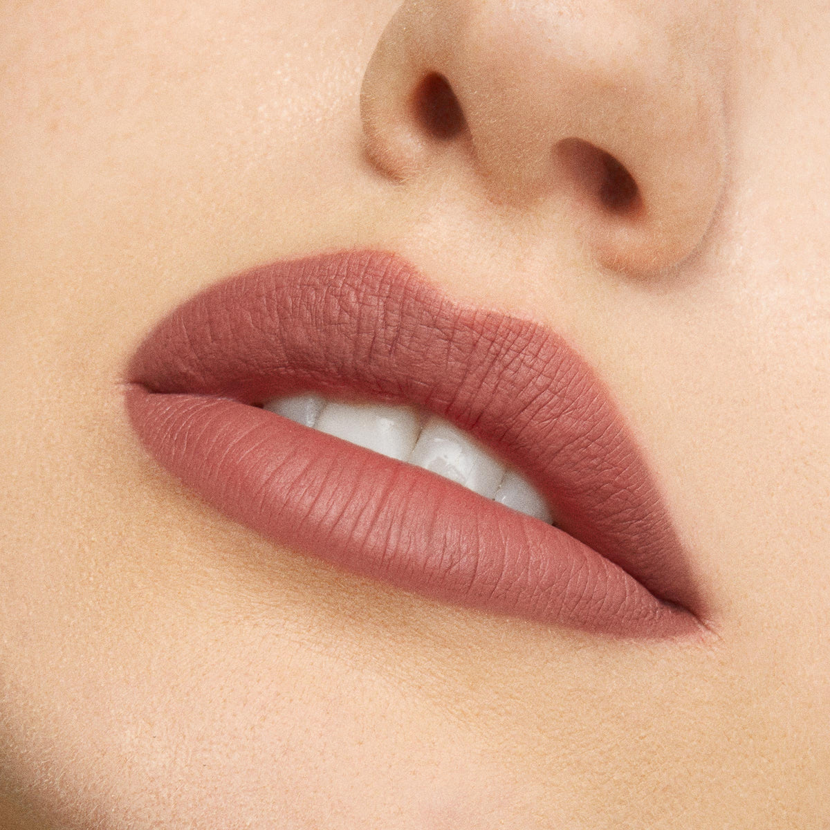 Lips wearing Beeper, a ColourPop Lippie Pencil, lining and filling the mouth in a soft matte neutral mauve-brown, shown in a close-up beauty shot to highlight crisp edges and full coverage.