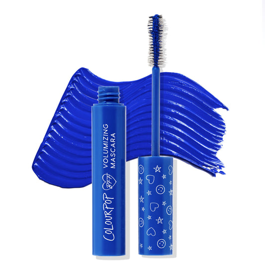 ColourPop BFF Mascara in Blue Ya Mind shows the open tube and wand, brush loaded with vibrant cobalt blue, as a bold swatch arcs behind on white; doodle-print cap and volumizing label spotlight the colorful, lash-lifting formula.