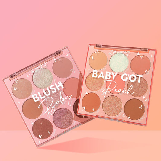 Two open nine-pan palettes from the Baby Got Blush ColourPop Shadow Palette Set, Blush Baby and Baby Got Peach, showing matte and shimmer pink, peach, and neutral shades in clear-lid compacts on a pink gradient backdrop.