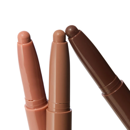 Matte Nudes ColourPop Shadow Stix trio, three uncapped cream eyeshadow pencils fanned to display peach nude, soft taupe, and deep cocoa tips, shown close-up on a white background.