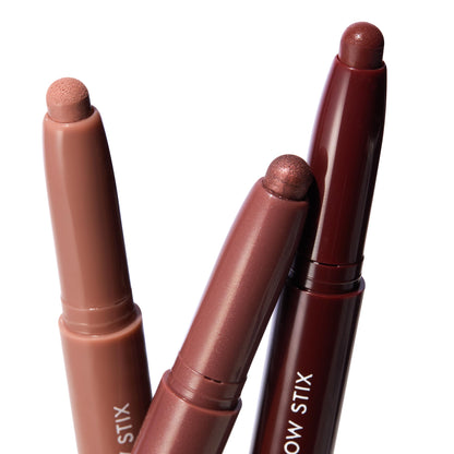 Three Burgundy Besties ColourPop Shadow Stix stand angled to show their twist-up domed tips in nude, rosy-mauve shimmer, and deep burgundy shimmer against a clean white background.
