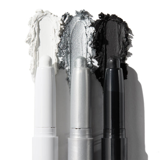 ColourPop Shadow Stix Totally Wicked trio shows uncapped pencils with rich swatches - matte white, metallic silver, and matte black - smeared behind each tip on a white background for bold smoky or graphic eye looks.
