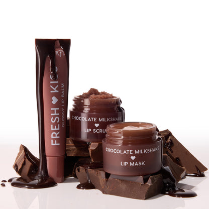 Triple Chocolate ColourPop Lip Care Kit featuring Fresh Kiss Glossy Lip Balm tube plus Chocolate Milkshake Lip Scrub and Lip Mask jars, chocolate dripping over rich brown packaging stacked on broken chocolate bars against a white background.