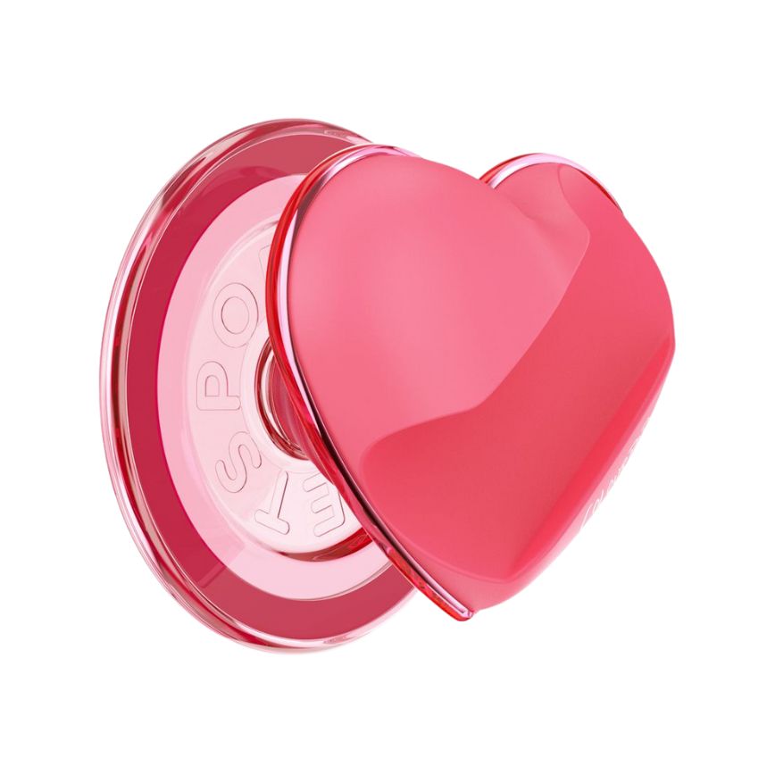 Heart-shaped glossy pink phone grip extends from a clear round base, side profile, featuring the ColourPopSockets design from the ColourPop x PopSockets collab on a white background, styled to pair with ColourPop Lip Stain.