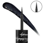 ColourPop Coven Graphix Ink Liner draws a sharp wing with an ultra-fine brush tip, shown beside a sweeping swatch of deep midnight black packed with silver sparkle; macro of the tip and glossy black cap with script on a white background.