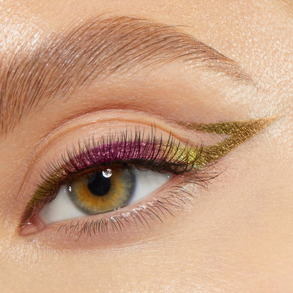 Pixie shade of the ColourPop Chrome Crème Gel Liner tracing a sharp metallic cat-eye on a hazel eye, shifting green to gold with pink‑lime iridescence along the lash line, close-up to show creamy payoff, high shine, and precise winged detail.