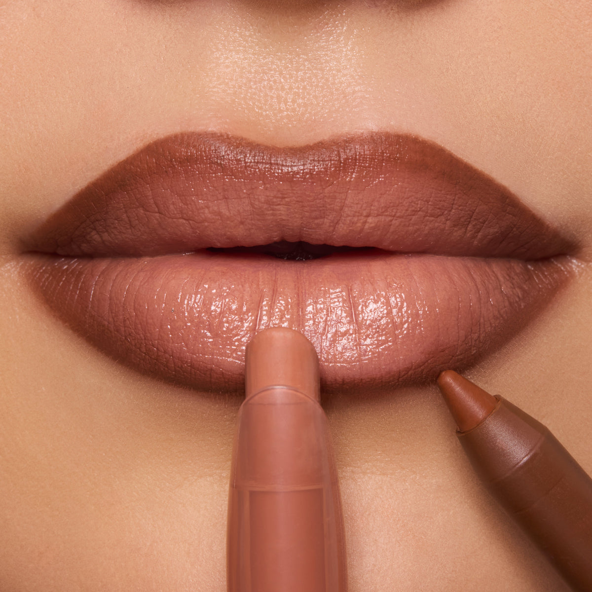 Glossy nude lips wear ColourPop Lippie Stix in the shade In the Nude, applied with a creamy bullet while a brown liner defines the edges; tight beauty close-up highlighting smooth payoff and precise lip contour.