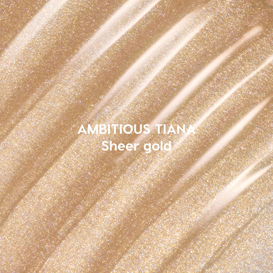 Ambitious Tiana Ultra Glossy Lip swatched in diagonal streaks of shimmering sheer gold, showcasing a sparkling Disney Princess–inspired lip gloss shade on a close-up textured background.