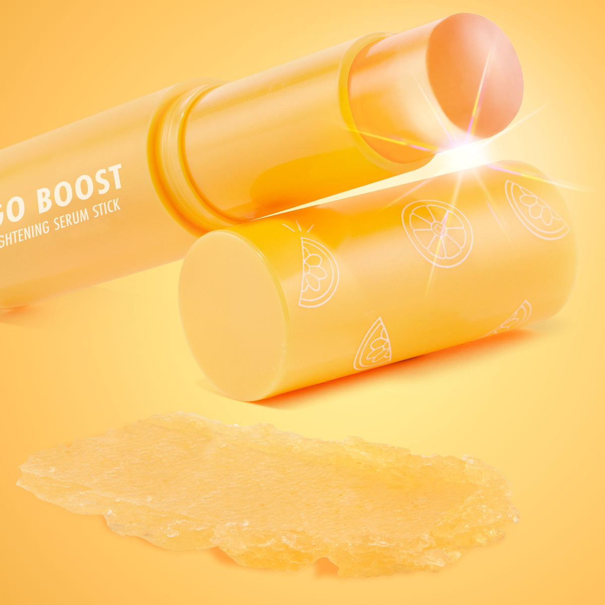 Ego Boost ColourPop Serum Stick uncapped, peach balm tip gleaming, yellow-orange tube labeled Brightening Serum Stick with citrus slice icons, and a creamy golden swipe of formula displayed on an orange gradient background.