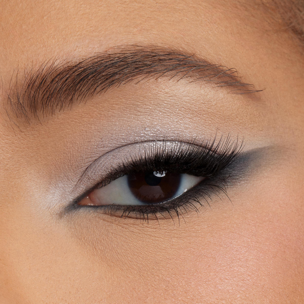 Smoky silver-to-charcoal eyeshadow blended to a soft wing on a close-up eyelid, showcasing the Blowin’ Smoke ColourPop Shadow Palette with shimmer lid, matte gray crease, and black liner and lashes for a dramatic cool-toned look.