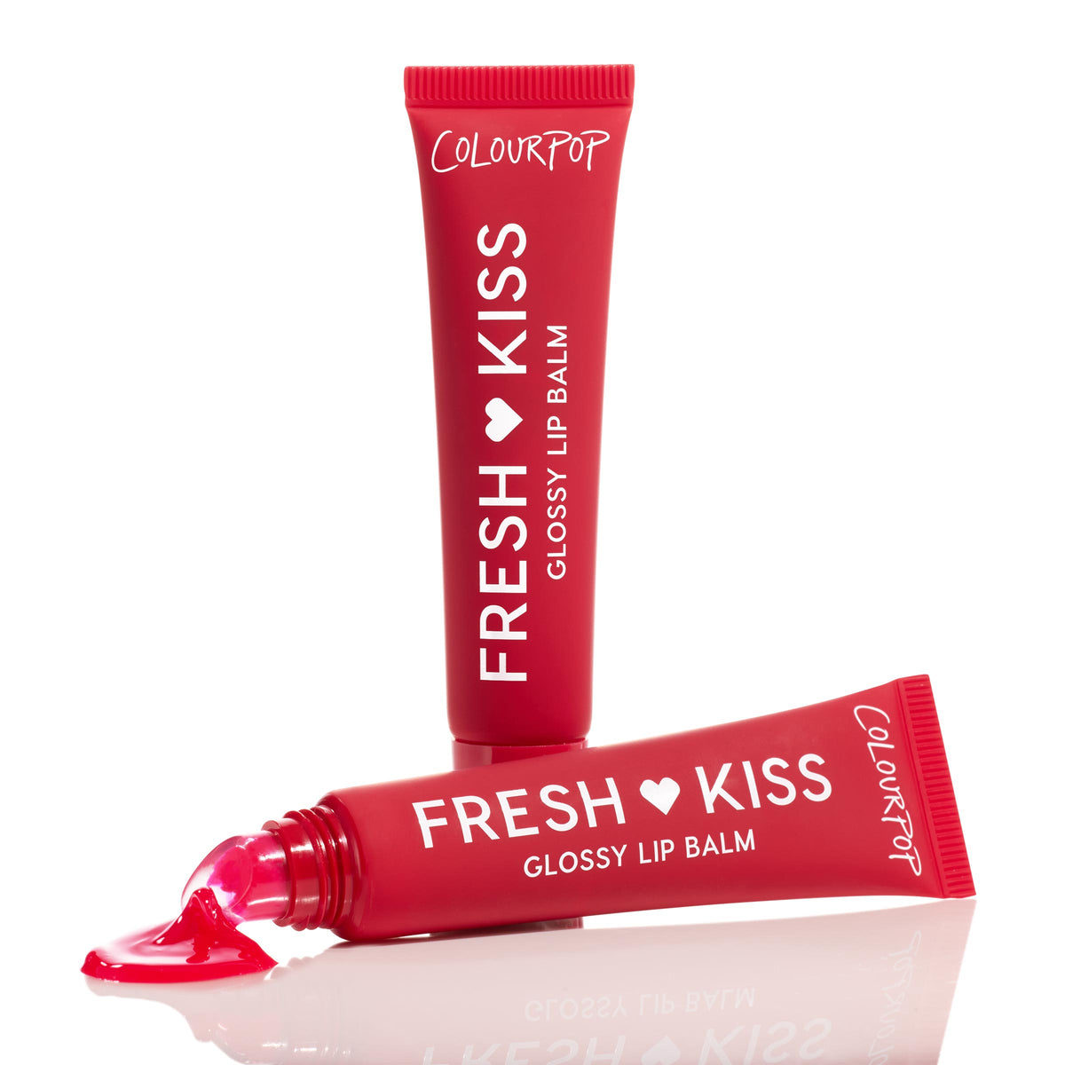 Cherry Glaze ColourPop Fresh Kiss Glossy Balm oozing from a slanted applicator and pooling in bright cherry-red gloss, with a second red squeeze tube standing upright behind on a clean, reflective white background.