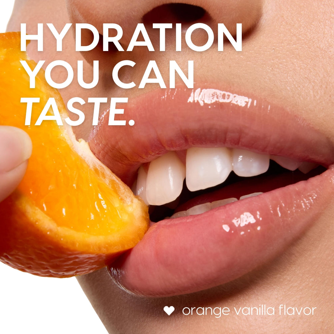Glossy, hydrated lips wearing the ColourPop Lip Mask in Orange Vanilla bite into a juicy orange slice, showcasing citrus flavor and high shine; bold overlay reads “Hydration you can taste” on a clean white background.