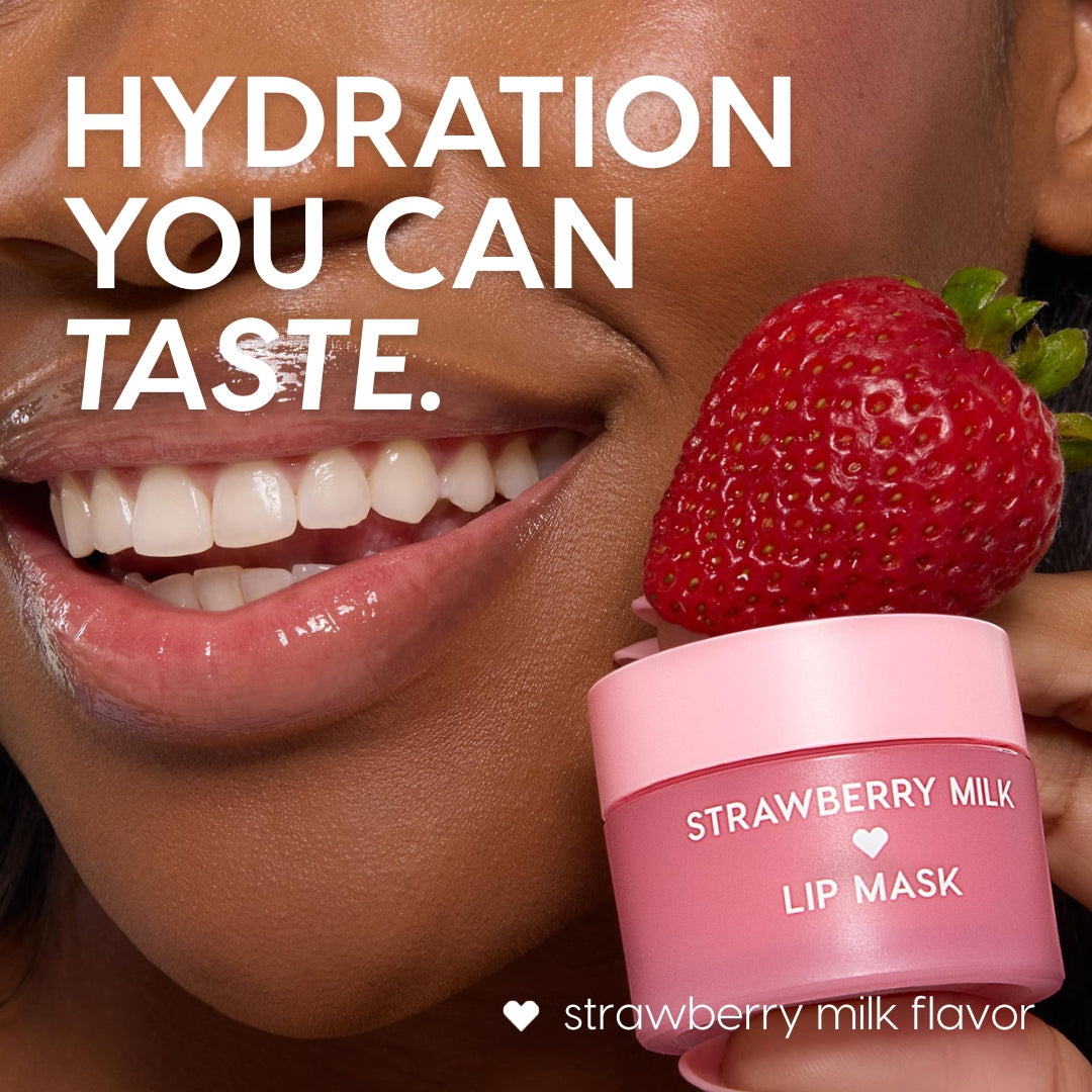 Strawberry Milk ColourPop Lip Mask jar held beside glossy, smiling lips, with a fresh strawberry perched on the pink lid, showcasing a sweet, hydrating lip treatment in a close-up beauty shot.