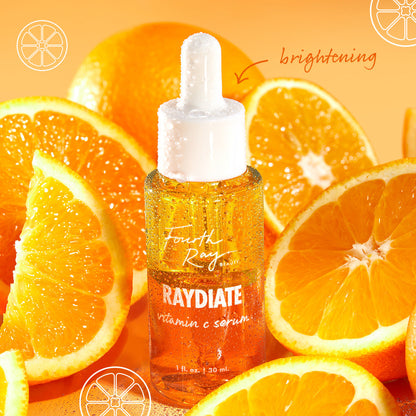 Fourth Ray Beauty Raydiate Vitamin C Serum 1 fl oz dropper bottle glistens with dew among fresh orange slices on a bright citrus background, highlighting brightening in the Get That Glow ColourPop Face Set.