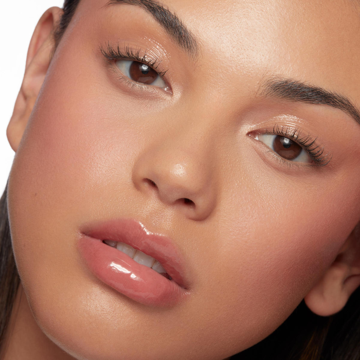 Glossy, peachy-pink lips wearing Hits Diff, ColourPop So Juicy Plumping Glossy Lip Oil, plumping to a smooth, glassy finish in a close-up beauty shot with dewy makeup and soft studio lighting.