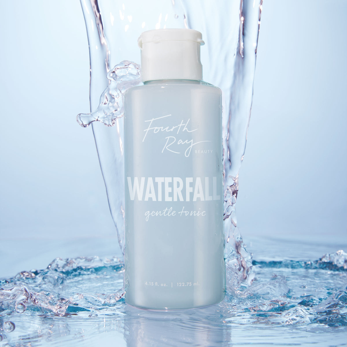 Fourth Ray Beauty Waterfall Gentle Tonic face toner standing upright as water splashes around it, showcasing a pale blue 4.15 fl oz bottle with white flip cap; hydrating ColourPop Face Toner in a fresh waterfall setting.