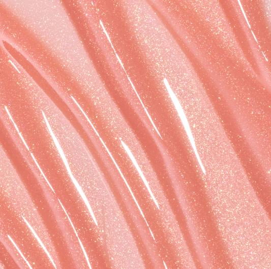 Colourpop Fresh Kiss Glossy Balm in Peach Mochi swatched in smooth, wavy streaks, showing a sheer peach Lip Gloss & Lip Oil texture with fine gold and pink sparkle against a close-up shimmering background.