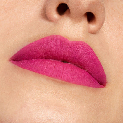 Lips wearing Heart On, a ColourPop Lippie Pencil, lining and filling the lips with a vibrant fuchsia pink matte finish in a tight close-up, showing smooth, even coverage and crisp edges.