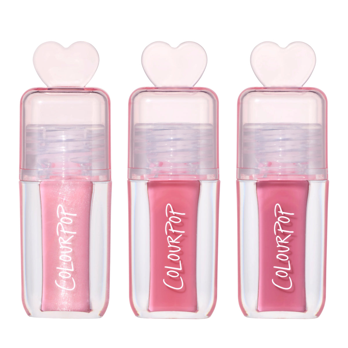 Three ColourPop Gloss Me Up ultra glossy lip set tubes from the Heart to Get collection standing upright, each in a clear pink case with heart-shaped cap and varying pink gloss shades on a clean white background.