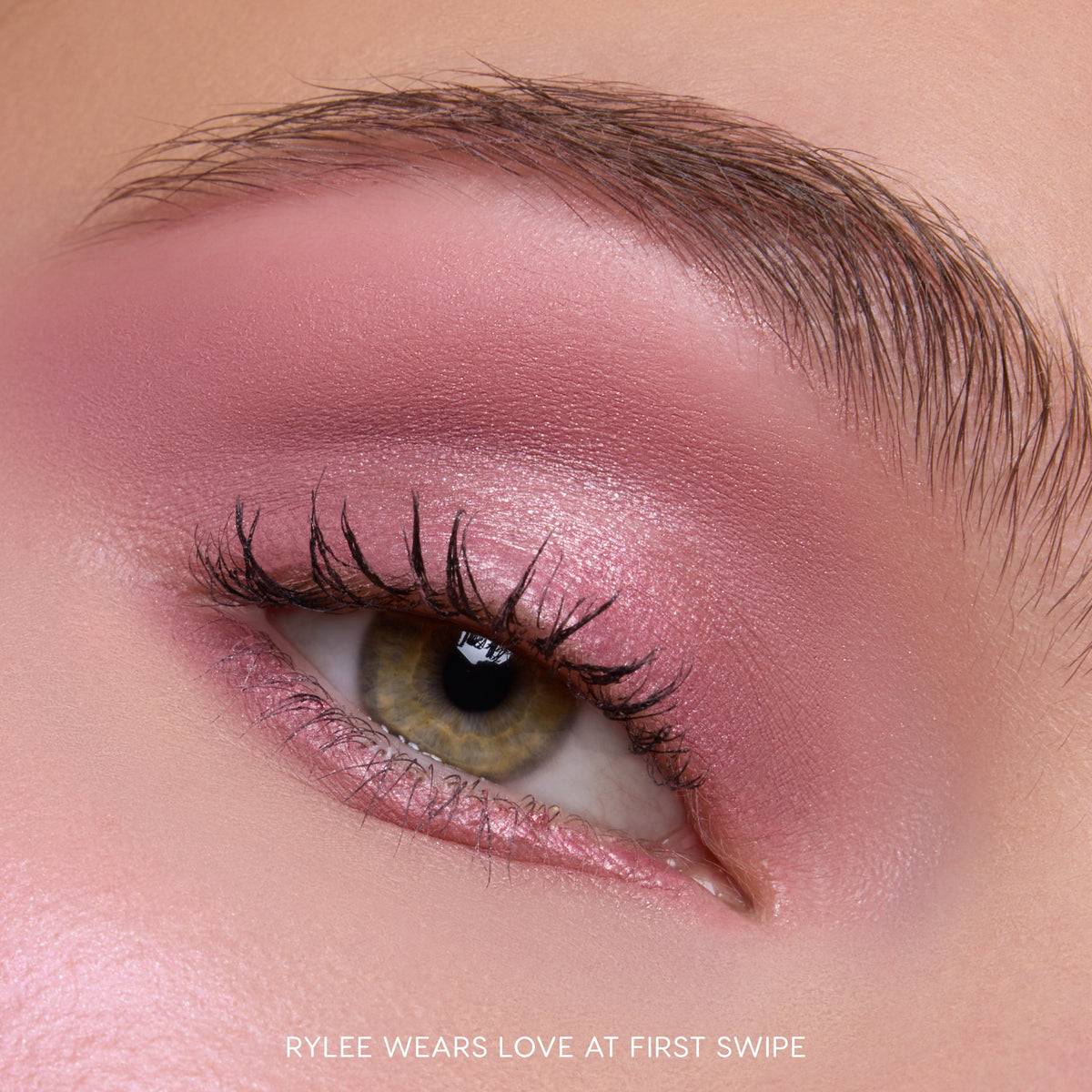 Close-up of a hazel eye wearing Heart to Get Love At First Swipe Shadow Stix, showing shimmery rose-pink eyeshadow blended from lash line to brow for a soft, romantic makeup look on smooth skin.