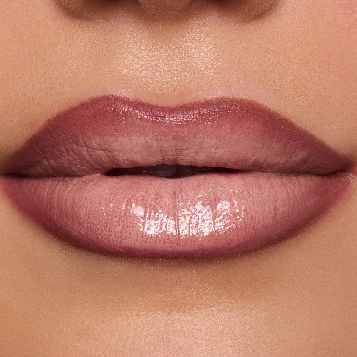 Full lips wear In the Nude Lippie Stix, a ColourPop Lippie Stix shade in pink-beige nude, applied evenly with a glossy satin sheen in a tight studio close-up.
