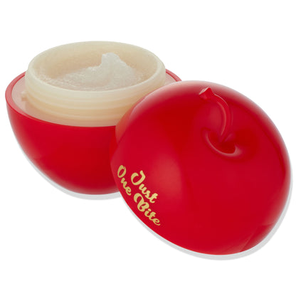 Just One Bite ColourPop Lip Scrub opens to reveal a creamy sugar scrub in an apple-shaped red jar with gold “Just One Bite” lettering, cap set beside on a white background; Snow White lip scrub product packaging close-up.