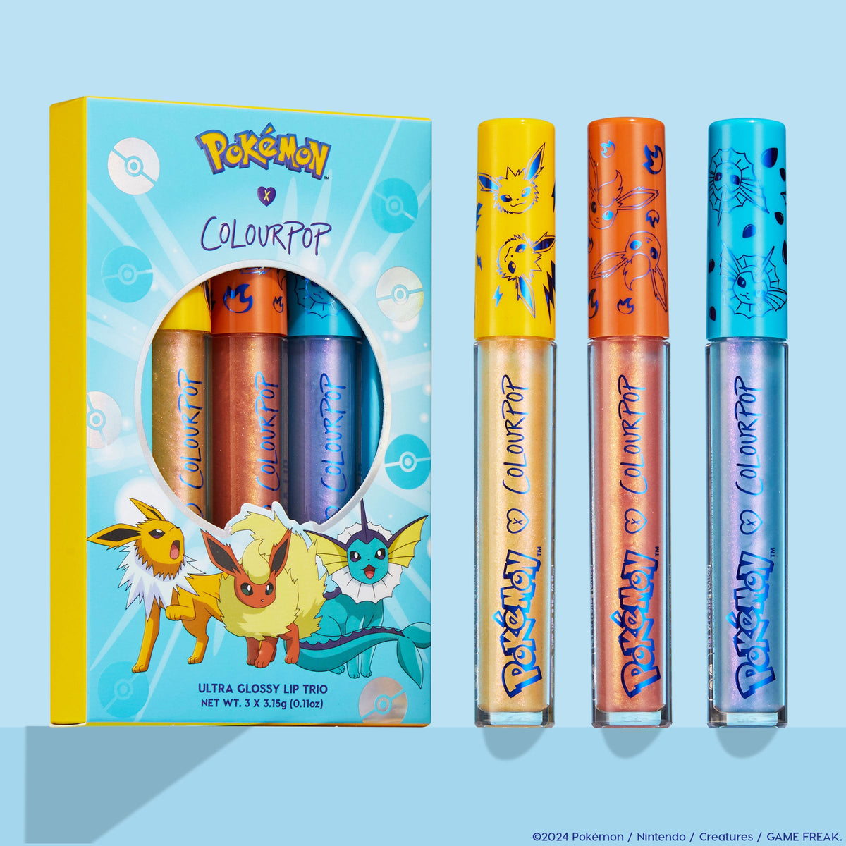 ColourPop Ultra Glossy Lip Evolution trio standing upright, three shimmer glosses - gold, peach, and icy blue - with Jolteon, Flareon, and Vaporeon caps, displayed beside the Pokémon x ColourPop box on a light blue background.