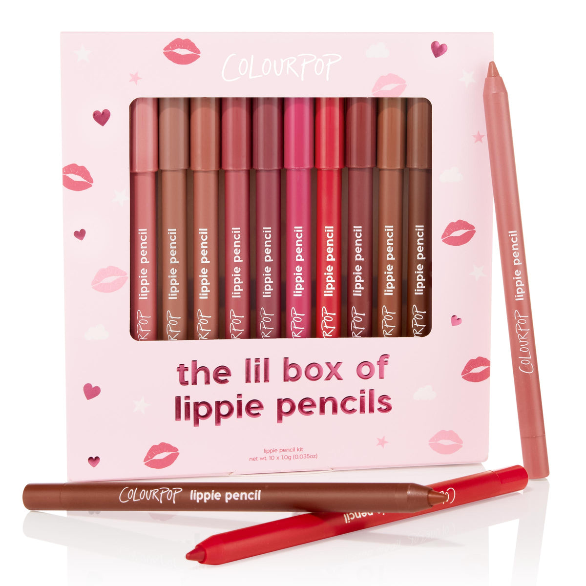 Ten ColourPop Lippie Pencil liners stand upright in The Lil Box of Lippie Pencils, showing nude, mauve, pink, red, and brown shades, with two pencils outside the pink lip-print packaging for detail - an everyday lip liner kit.