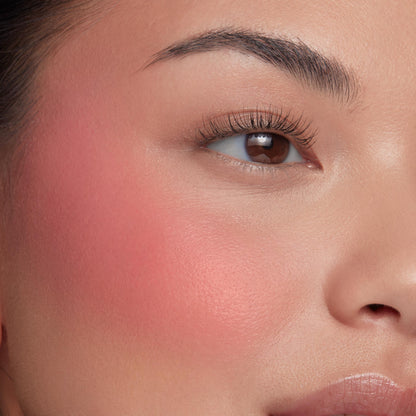 Culver City ColourPop Liquid Blush creating a soft coral-pink flush, diffused across the upper cheekbone on a close-up face, with natural lashes and a hydrated, dewy finish that highlights smooth blendability and payoff.