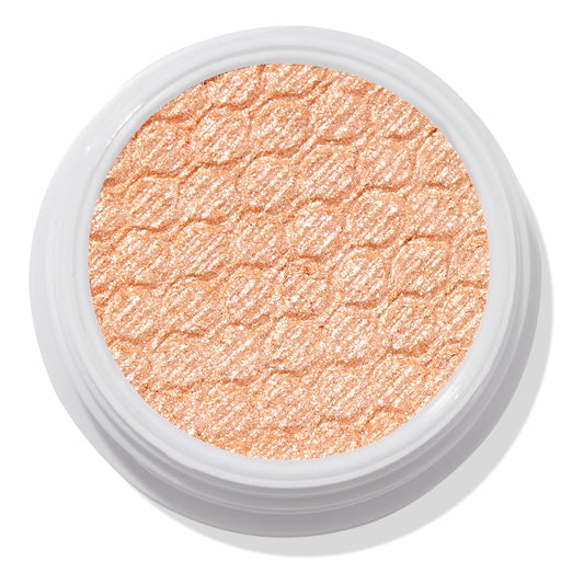 La Mesa ColourPop Super Shock Shadow sits in an open white pot, its warm peachy-champagne shimmer and quilted honeycomb texture catching the light in a close-up top view on a white background.