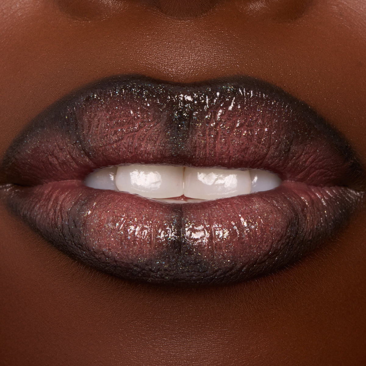Glossed lips wearing ColourPop Ultra Glossy Lip Coffee Break, a sheer cocoa-brown gloss with fine multidimensional sparkle, reflecting high shine as the mouth softly parts to show teeth in a tight beauty swatch.