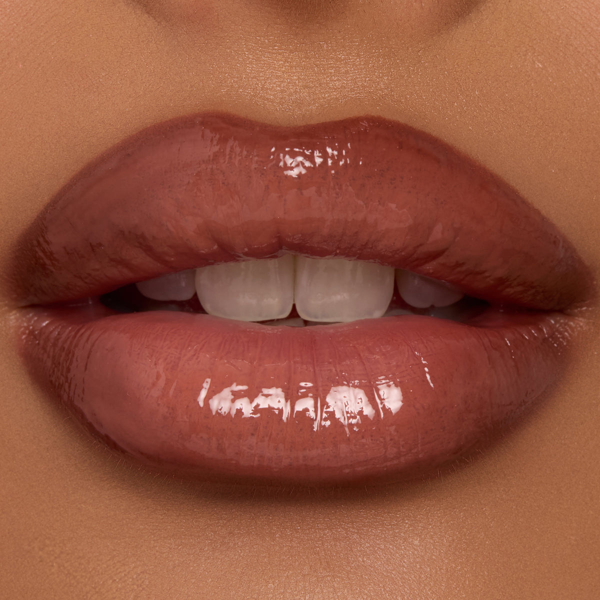 Lips wearing ColourPop Coffee Break Ultra Glossy Lip, a warm coffee-brown nude, reflecting high-shine gloss as they part slightly to reveal teeth in a tight close-up, showcasing smooth texture and even, full coverage.